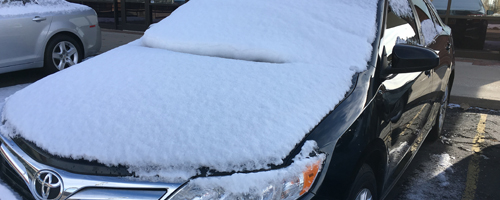 Snow covers windshield of a car